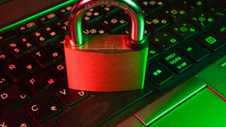 Red and green padlock resting on a computer keyboard, symbolizing a scoped API key that locks down account access