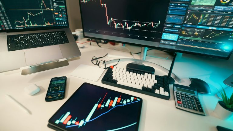 Candlestick charts on multiple screens asking do crypto trading bots work
