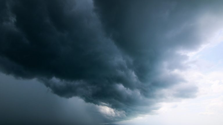 Storm moving across the sky over open water, a metaphor for a regime filter trading strategy reading market conditions